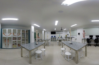 Laboratório de Anatomia Humana Ciências Morfofuncionais – Medicina Guarujá - equipado com 02 televisores de LED com 55 polegadas, além de freezer horizontal, jogo de computadores, projetor, chuveiro de emergência com lava-olhos, microscópios, bandejas retangulares de inox, caixa de inox (estojo), pinças anatômicas, tesouras cirúrgicas e diversos manequins simulares (esqueleto humano, braço vascular, ossos do membro superior, além de muitos outros.