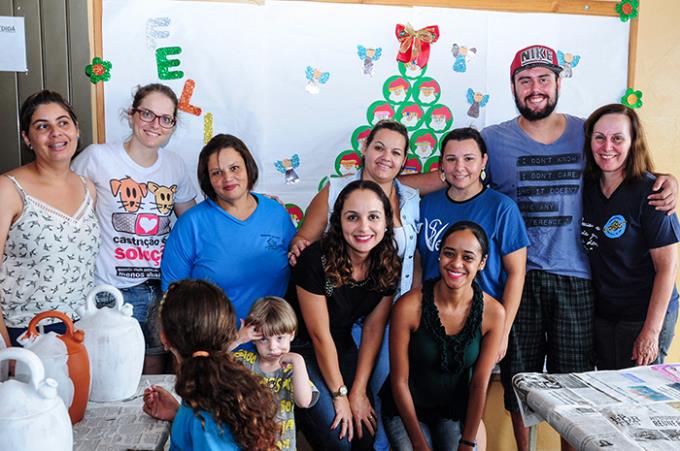 Acadêmicos auxiliam crianças em pintura de vasos