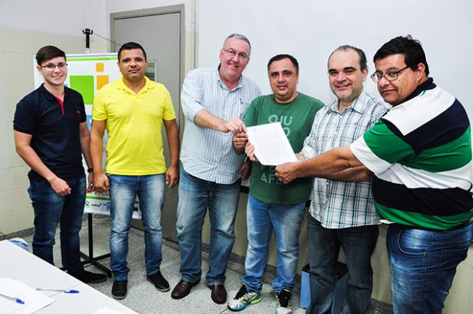 Assinatura do contrato por representantes do projeto No Stop Market