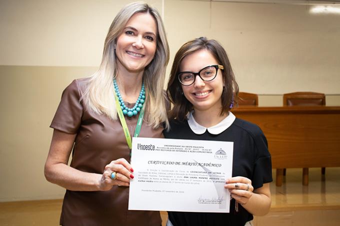Acadêmica Ana Laura recebe certificado de mérito da coordenadora da graduação Luciane Cachefo