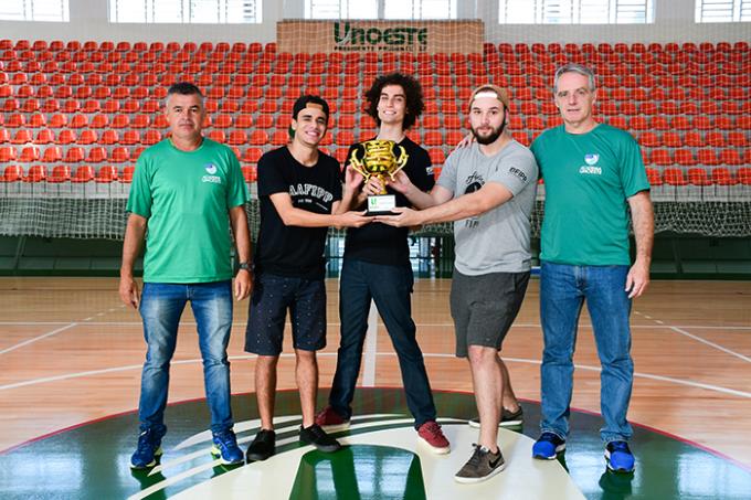 Marcel Marangoni e Edilson Andrade da Coordenadoria de Esportes entregam o troféu de campeão geral para a Fipp