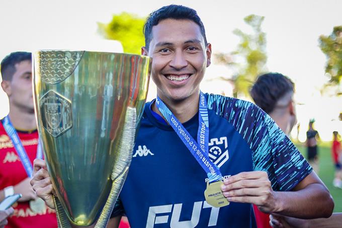 O fisioterapeuta do Grêmio Prudente Fidelis Junior exibe com orgulho o troféu conquistado pelo Grêmio Prudente na Segundona em 2022