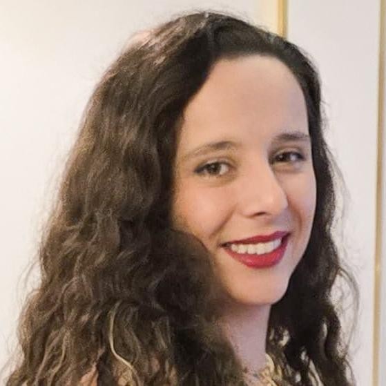 Foto de Melissa, aluna por transferência Medicina em Jaú. Ela é uma mulher branca, sorridente, com cabelos castanhos longos e cacheados.