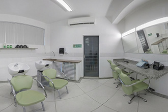 Laboratório de Habilidades Terapêuticas V – com lavatórios e poltronas hidráulicas, equipados com secadores e pranchas de cabelo, cosméticos de tratamento capilar, capacetes de luzes infravermelhas e microscópios de captura de imagens