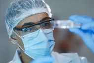 Estudante de medicina da Unoeste realiza pesquisa em laboratório, analisando um tubo de ensaio com atenção.