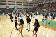 Estudantes dançando em grupo na quadra esportiva da Unoeste durante um evento.