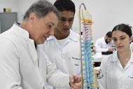 Professor ensina estudantes de medicina com um modelo de coluna vertebral.