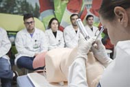 Estudantes de medicina em aula prática com manequim.