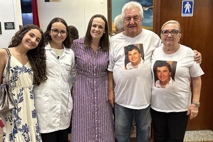 A caloura Isabelle Marques Ferron, de jaleco, junto com a família que prestou homenagens ao pai Rodrigo Prado Ferron, vítima de Covid-19 em 2021