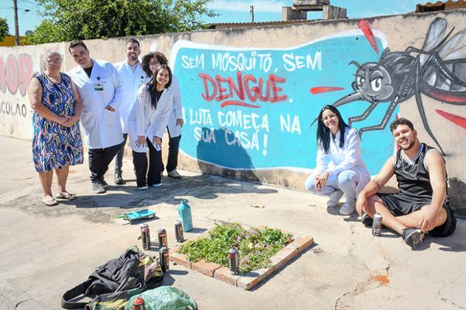 Dona Maria Rosária, alunos e João Célio ao lado do grafite