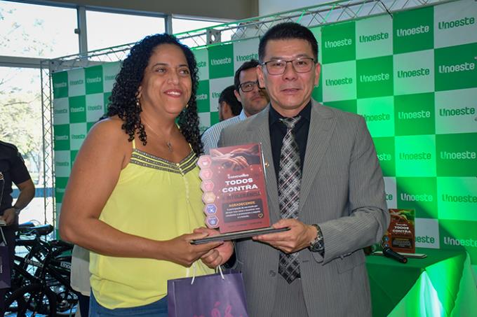 Diretora da escola Odette Duarte, Luciana Souza recebe a premiação entregue pelo Dr. Akira
