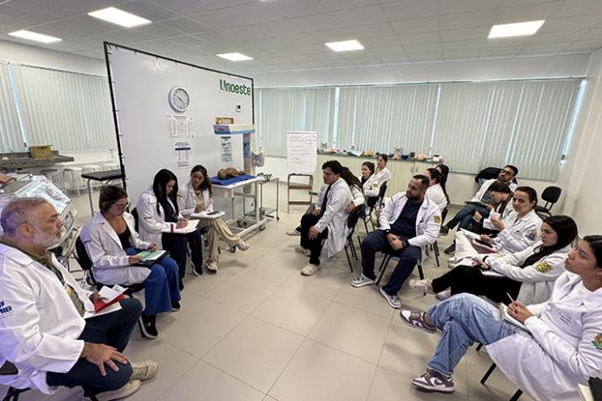 Professor conduz roda de conversa com alunos durante atividade prática